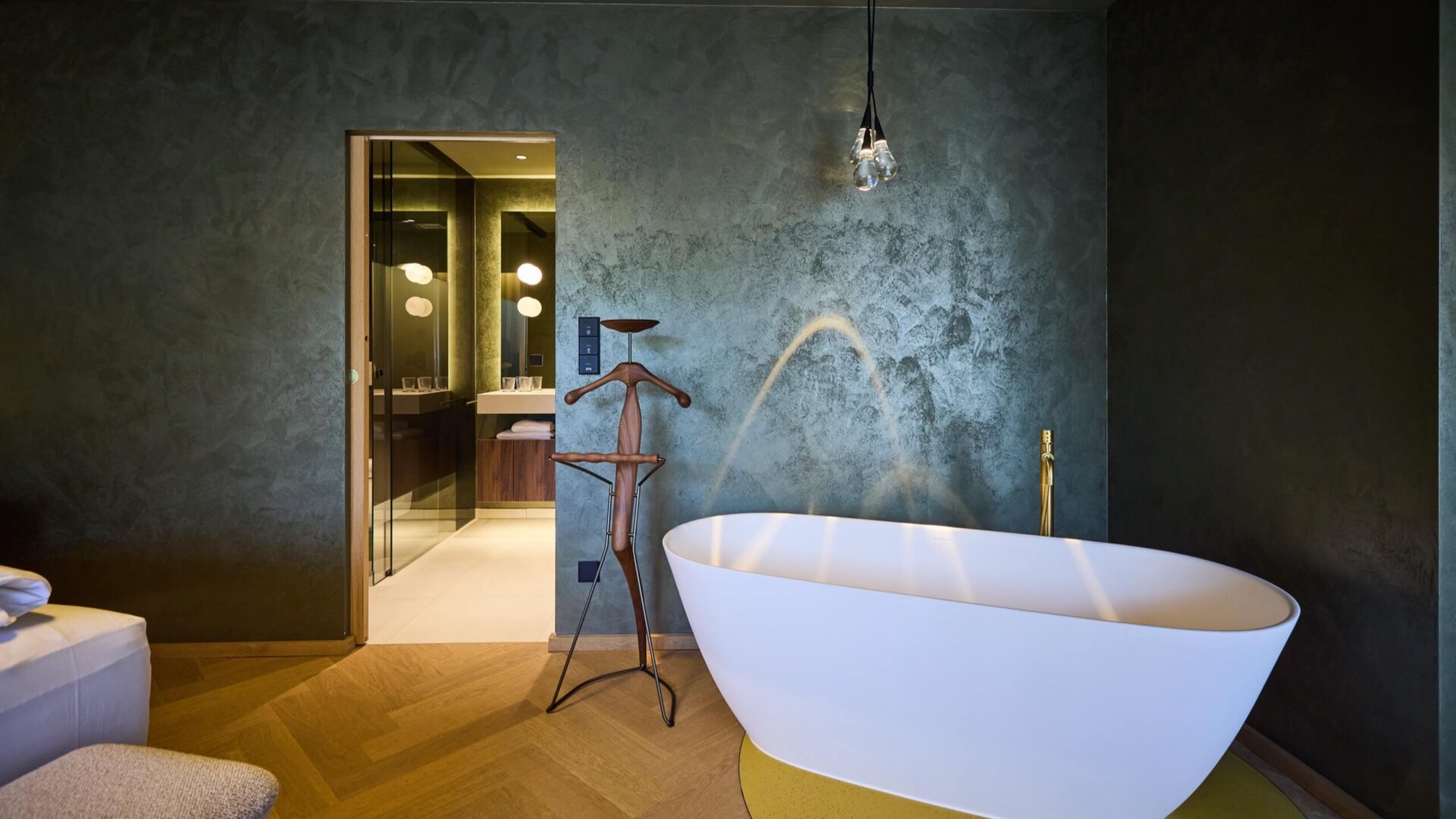 Freistehende Badewanne und Blick ins Badezimmer in einer Suite im Hotel nōa Schladming