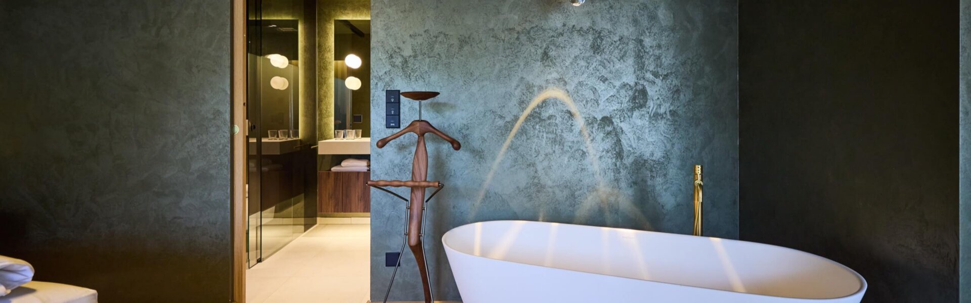 Freistehende Badewanne und Blick ins Badezimmer in einer Suite im Hotel nōa Schladming