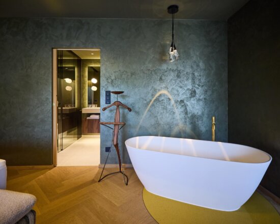 Freistehende Badewanne und Blick ins Badezimmer in einer Suite im Hotel nōa Schladming