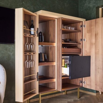 Schrank mit Wasserkocher, Minibar, Kaffeemaschine, Wein und Gläsern