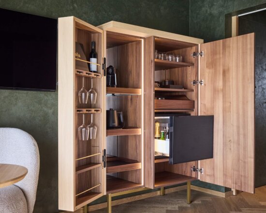 Schrank mit Wasserkocher, Minibar, Kaffeemaschine, Wein und Gläsern
